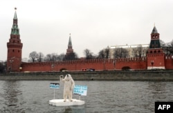 Wearing a polar bear costume, a Greenpeace activist takes part in a protest on the Moskva River in front of the Kremlin in Moscow on April 1 to draw attention to the consequences of Arctic oil drilling..