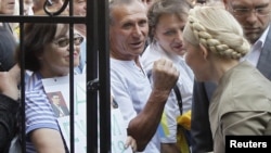 Ukrainian former Prime Minister Yulia Tymoshenko (right) greets supporters before entering the Prosecutor-General's Office in Kyiv.