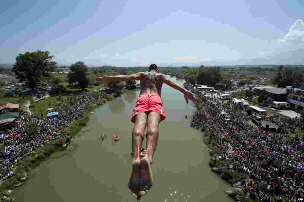 A diver jumps from the 22-meter-high Ura e Shenjte Bridge during a high diving competition near the town of Gjakova, Kosovo on August 11. (AFP/Armend Nimani)