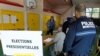 Полицейский наблюдает, как проходит первый тур президентских выборов во Франции 
