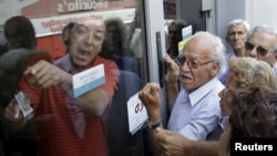 Penzioneri pred ulazom u banku zahtijevaju isplatu penzija. Atina, 29. juni 2015.