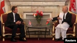 Afghan President Ashraf Ghani (R) speaks with British Prime Minister David Cameron during their meeting at the presidential palace in Kabul, October 3, 2014.