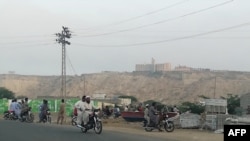 Pakistan -- Pakistani residents watch from a road the five-star Pearl Continental hotel, located on a hill (top back) in the southwestern Pakistani city of Gwadar, on May 11, 2019. 