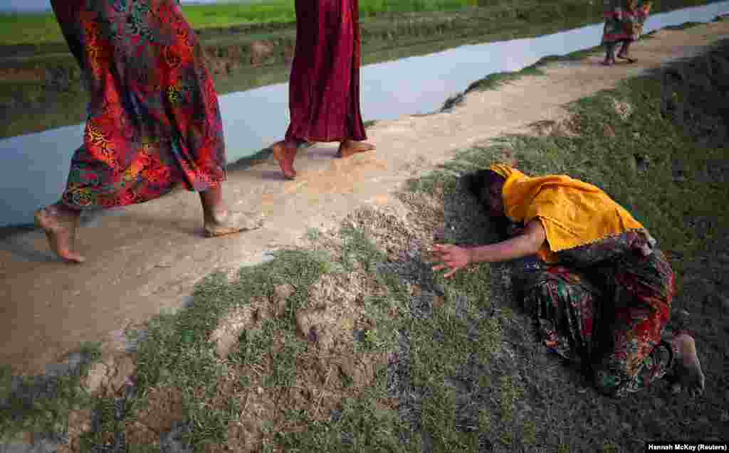 An exhausted Rohingya refugee cries for help as other refugees continue on their way after crossing from Myanmar into Palang Khali, near Cox&#39;s Bazar, Bangladesh. (Reuters/Hannah McKay)