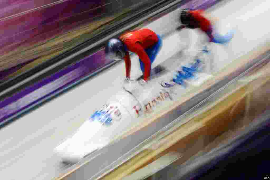 A Russian two-woman bobsleigh steered by Nadezhda Sergeyeva takes a practice run during a training session at the Sanki Sliding Center. (AFP/Lionel Bonaventure)