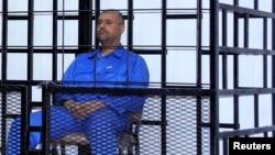 Saif al-Islam Qaddafi, the second son of Libya’s late dictator Muammar Qaddafi, attends a hearing behind bars in a courtroom in Zintan, Libya, in 2014. 