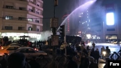 In Tehran, a water canon is used in Ferdowsi Square in an attempt to disperse demonstrators on December 31.