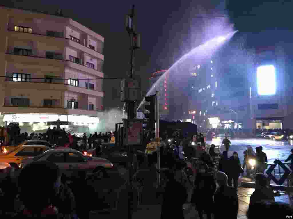 Полиция использует водометы для разгона протестующих на площади Фирдоуси в Тегеране.
