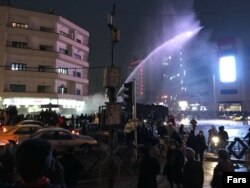 Authorities try to disperse demonstrators by using a water cannon in Ferdowsi Square on December 31.