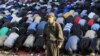 A member of Russia&#39;s security forces stands guard while Muslims pray to celebrate Eid al-Fitr, marking the end of Ramadan, in Moscow on August 19. (REUTERS/Sergei Karpukhin)