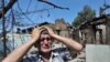 An ethnic Uzbek man stands beside the wreckage of his burned-out home in Osh on June 14, 2010.