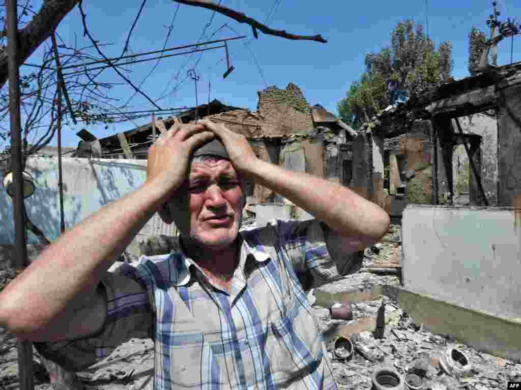 An ethnik Uzbek stands beside the wreckage of his burned-out home in Osh on June 14.