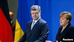 Президент України Петро Порошенко (в центрі) під час прес-конференції з канцлером Німеччини Анґелою Меркель, Берлін, 1 лютого 2016 року