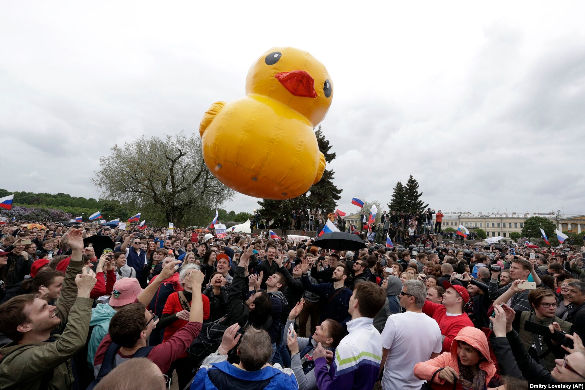 People play with a toy duck, adopted as a symbol of Medvedev's alleged wealth, during an anti-corruption rally in St. Petersburg on June 12, 2017. Medvedev became a target of anti-corruption protesters after a video released by opposition leader Aleksei Navalny purported to show his extravagant properties featuring helipads, a ski slope, and a house for ducks.   