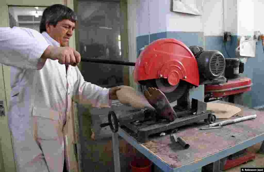 An Afghan man makes a prosthesis at the International Committee of the Red Cross's orthopedic center in Kabul. (EPA/S. Sabawoon)