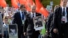 Russian President Vladimir Putin (center) carries a portrait of his father as he takes part in the Immortal Regiment march during the Victory Day celebrations in Moscow on May 9, 2015.