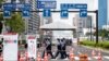 Полицейские проходят мимо одного из входов в Олимпийскую деревню в Токио 13 июля 2021 г.