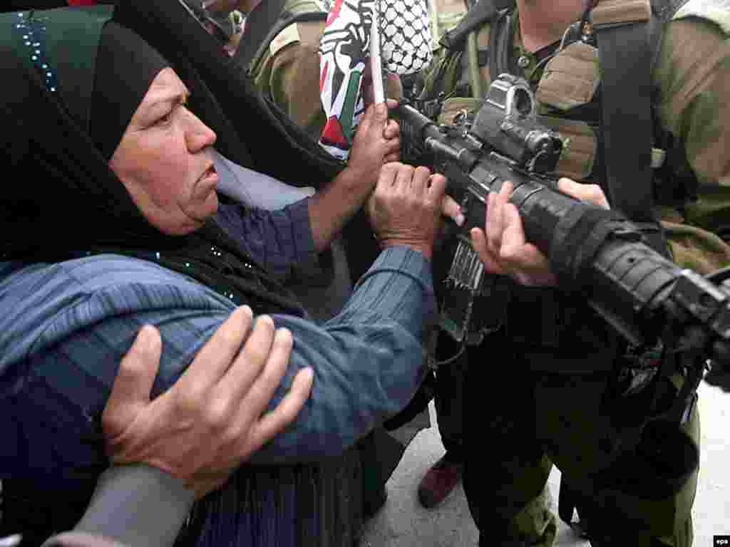 Palestina - Protiv zida - Palestinski demonstranti se guraju sa izraelskim vojnicima,pokušavajući da spriječe gradnju zida koji odvaja njih i Izraelce. Tel Aviv tvrdi da zid diže iz sigurnosnih razloga.