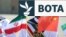 Një ushtar mban lart flamujt kombëtarë iranianë dhe kinezë gjatë stërvitjeve të përbashkëta detare midis Iranit, Rusisë dhe Kinës në portin iranian, në Gjirin e Omanit, në vitin 2019.