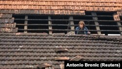 Meštanka sela Brest Pokupski, nedaleko od Zagreba, posmatra štetu na krovu svoju kuće nakon zemljotresa 28. decembra 2020. 