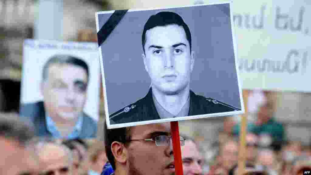 Hungarian demonstrators hold up a photo of Armenian Army Lieutenant Gurgen Margarian in front of the parliament building in Budapest, after his murderer was pardoned in Azerbaijan. (AFP/Attila Kisbenedek)
