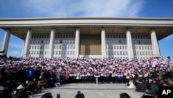 Membri ai Partidului Democrat, opus președintelui Yoon, la un miting de protest în fața Adunării Naționale, la 4 decembrie.