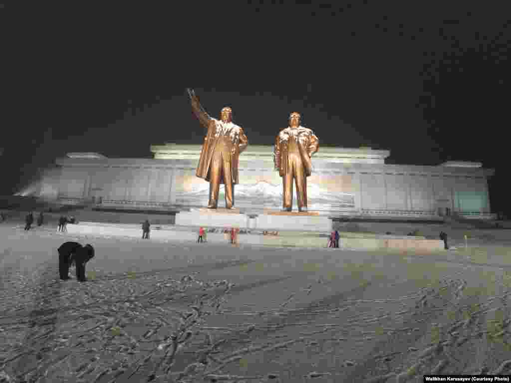 Гігантські бронзові пам&#39;ятники Кім Ір Сену і Кім Чен Іру на пагорбі Мансі у Пхеньяні. За монументом &ndash; будівля музею Революції.
