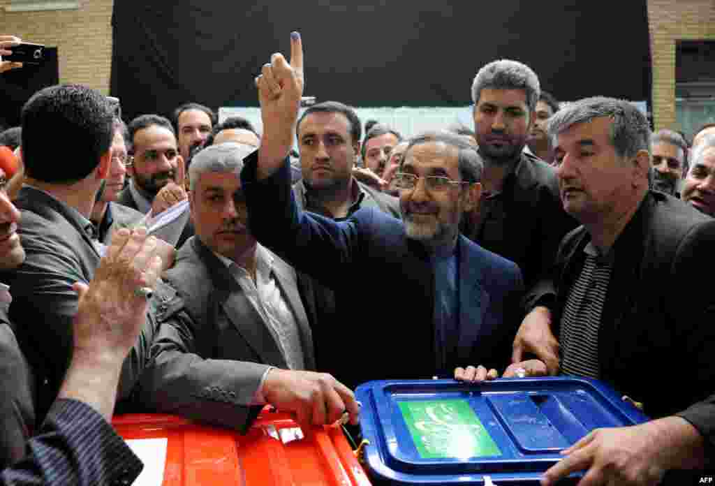 Presidential candidate Ali Akbar Velayati shows his ink-stained finger as he votes at a polling station in Tehran.