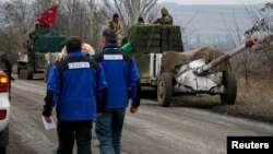Спостерігачі ОБСЄ біля колони з важким озброєнням українських сил, яке відводять від лінії зіткнення, 26 лютого 2015 року