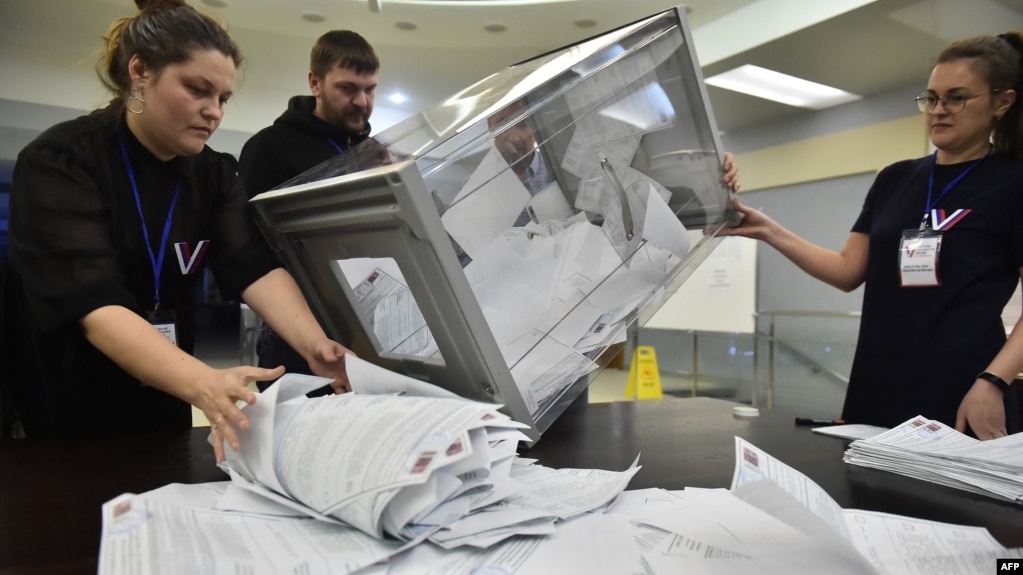 Members of a local electoral commission count ballots during at a polling station in Novosibirsk, Russia, on March 17.