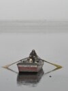 PAKISTAN - A man rows his boat in the waters of river Ravi engulfed in smog in Lahore on November 13, 2024.