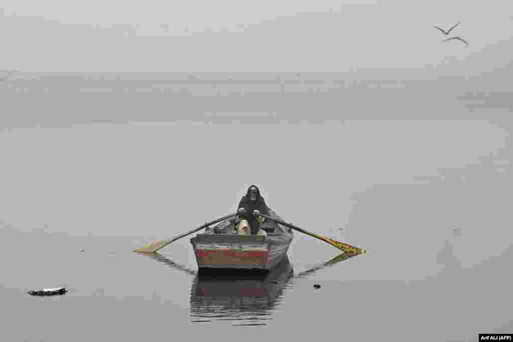 A man rows his boat in the waters of the Ravi River engulfed in smog in Lahore, Pakistan.