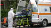 Romanian paramedics transport a patient with covid-19 symptoms to a hospital