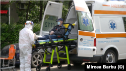 Romanian paramedics transport a patient with covid-19 symptoms to a hospital