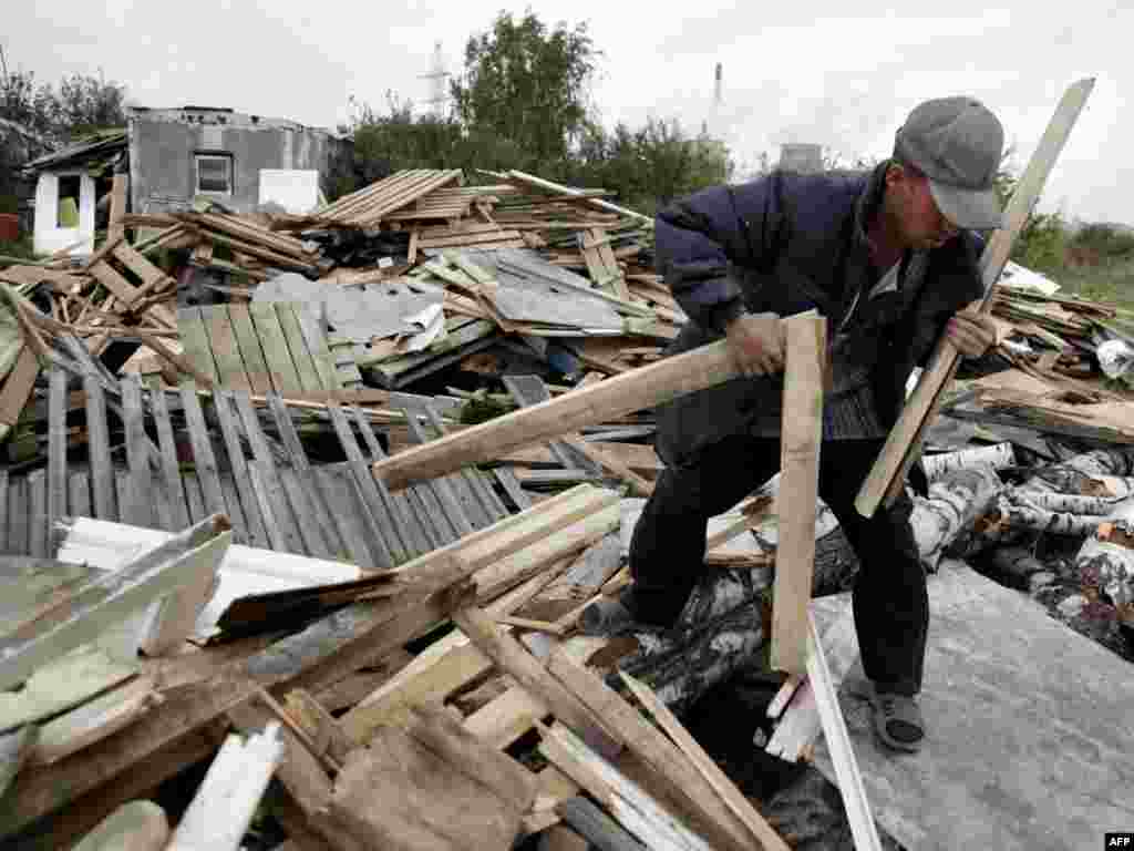 Russia -- A Tajik migrant worker gathers wood in Moscow on 23Sep2009 - RUSSIAN FEDERATION, Moscow : TO GO WITH AFP STORY BY Akbar BORISOV A Tajik migrant worker gathers wood in Moscow on September 23, 2009. Stuck working abroad for years at a stretch to escape Tajikistan's crushing poverty, some men have begun divorcing their wives using short mobile text messages (SMS), sowing confusion, heartbreak and destitution back home.