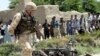 A British soldier next to the wreckage of a car used in a suicide attack on May 21