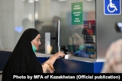 An ethnic Kazakh woman arrives in Kazakhstan on a flight from Kabul.