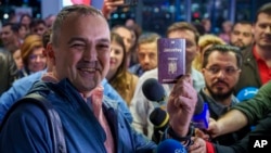 A passenger who arrived on a flight from Vienna shows his passport after being one of the first people to take advantage of Romania's entry in the Schengen Area without border checks by air and sea at the Otopeni airport near Bucharest on March 31.