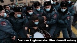 Арманистон хавфсизлик кучлари бош вазир истеъфосини талаб қилиб, кўчага чиққан намойишчилардан бирини тутиб кетмоқда, Ереван, 2020 йил 8 декабри.