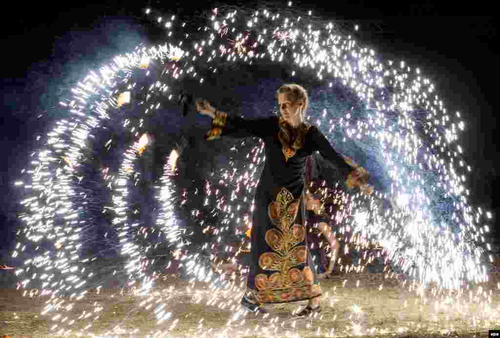 A woman performs a fire show at the Cucuteni International Festival near the village of Ivancea, north of Chisinau, Moldova. The Cucuteni festival is an arts event dedicated to the preservation of the traditional arts, as well as the promotion of local brands and artisans. (epa/Dumitru Doru)