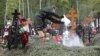 A man wearing protective gear pours a white substance into a grave during a funeral at a cemetery amid the outbreak of the coronavirus disease in Moscow on May 26.