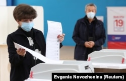 A woman casts her ballots at a polling station during parliamentary elections in Moscow on September 19.