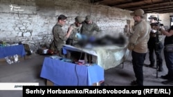 Пошуковці оглядають останки військовослужбовця армії Росії, 8 червня 2026 року
