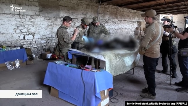 Пошуковці оглядають останки військовослужбовця армії Росії, 8 червня 2026 року