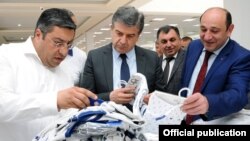 Armenia - Prime Minister Karen Karapetian (C) and Economic Development Minister Suren Karayan (R) visit a textile factory in Yerevan, 19 June, 2017.