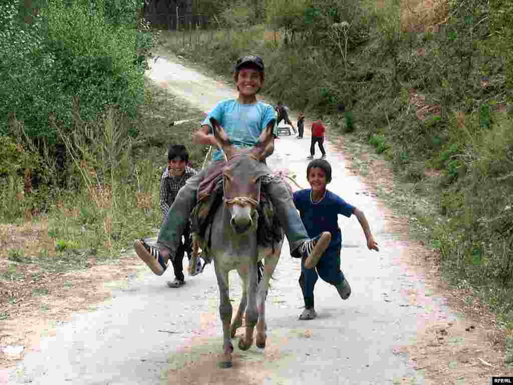 Tajikistan -- kids play on donkey in eastern Tajik village of Chormaghz; Sept 2008 (photo for RFE/RL Tajik Service by Munavvar Munavvarzad) - Tajikistan -- kids play on donkey in eastern Tajik village of Chormaghz; Sept 2008 (photo for RFE/RL Tajik Service by Munavvar Munavvarzad)