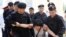 Kazakh police officers detain an opposition supporter attempting to stage a protest rally in Almaty on June 23. 