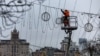 A worker installs Christmas lights above a street in Kyiv on December 4. 