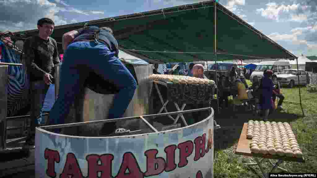 Чоловіки готуються випікати коржі в тандирній печі