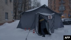Pripadnik spasilačkih ekipa u Kijevu otvara šator na takozvanoj tački nesalomivosti, gde ljudi mogu da pune mobilne uređaje i da se greju usred surovih zimskih uslova u gradu, 9. januar 2026.